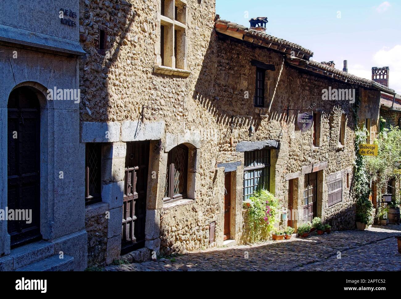 Street scene, ciottoli, vecchie case in pietra, piante, texture, ombra, sole, collina, borgo medievale murato, 14-15 secolo, Perouges, Francia, estate; hor Foto Stock