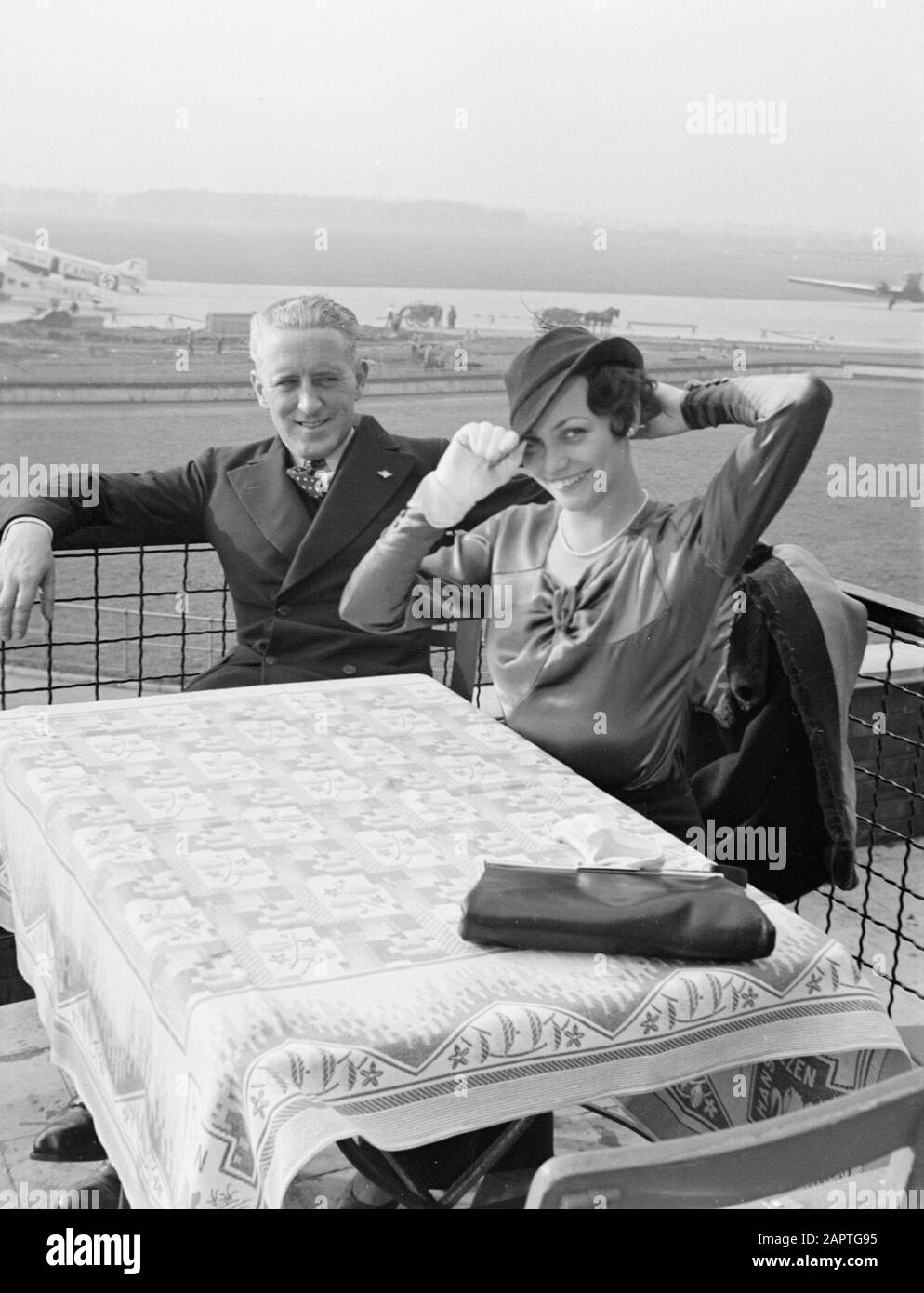 Aeroporto di Amburgo Harry Laponder con una donna sconosciuta sulla terrazza dell'edificio dell'aeroporto con in background un BFW M.20 D-UMOK e un Wibault 280.T F-ANBL Data: 13 agosto 1934 posizione: Germania, Amburgo Parole Chiave: Visitatori, aviazione, compagnie aeree, terrazze, aeromobili, personale aereo, aeroporti Nome personale: Laponder, Harry Foto Stock