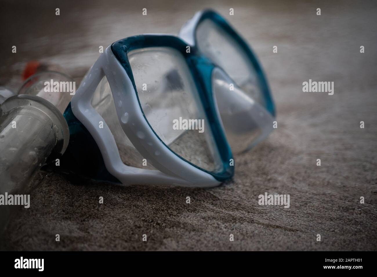 Maschera e snorkeling nel surf sulla spiaggia di sabbia; fuoco selettivo, maschera e tubo di snorkeling sulla sabbia Foto Stock