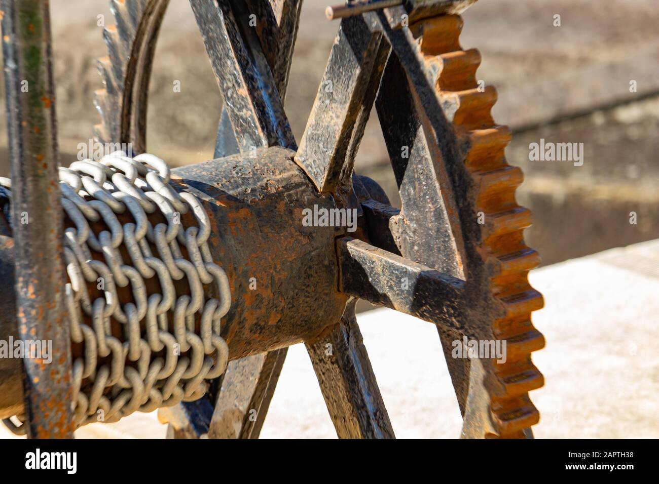 Un argano a granchio metallico arrugginito, usato a mano per controllare le porte di bloccaggio in una stazione di bloccaggio, è visto da vicino, mostrando la sua ruota dettagliata. Foto Stock