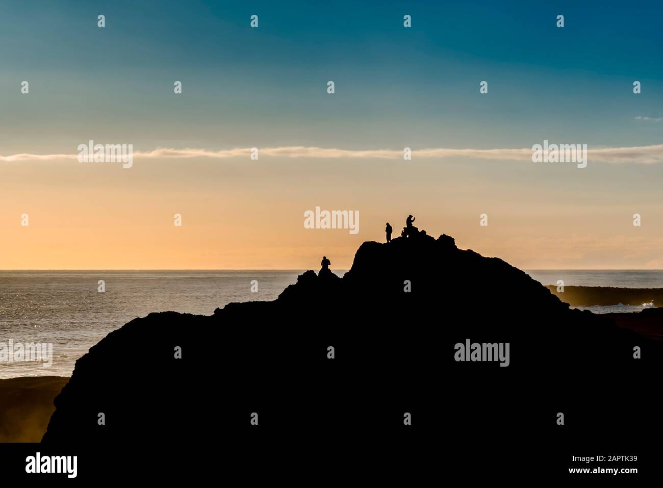 Gli amici si godono la vista vicino al faro di Reykjanes al tramonto, penisola di Reykjanes; Islanda Foto Stock