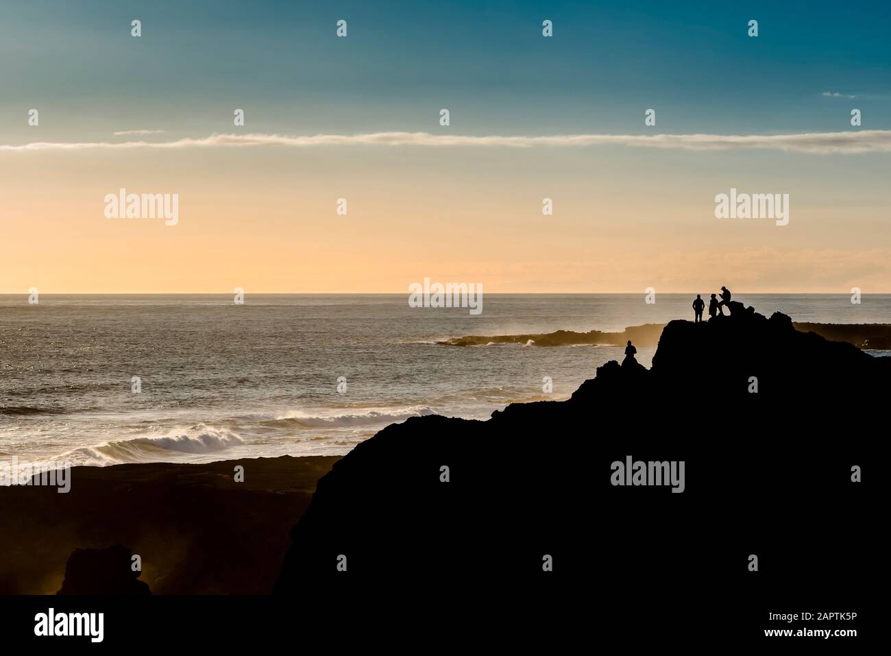 Gli amici si godono la vista vicino al faro di Reykjanes al tramonto, penisola di Reykjanes; Islanda Foto Stock