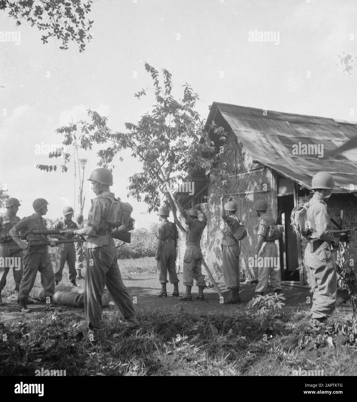 V.P.T.L. [Evacuazione di una casa circondata] [non lasciare che i residenti uscire dalla casa allo stesso tempo] Annotation: V.P.T.L. = prescrizione per l'esercizio del compito di polizia politica dell'esercito (che agisce contro i combattenti guerriglia). Questa regola di KNIL risale al 1928, apparsa nel 1936 e fu modificata e integrata nel 1945 e pubblicata nuovamente nel 1946, ora soprattutto per il KL. La serie fotografica è stata utilizzata per la brochure Knowledge of the V.P.T.L., a Mengetahoei akan V.P.T.L., soal hidoep atau lati [DJK] Data: 1946 luogo: Indonesia, Indie Orientali olandesi Foto Stock