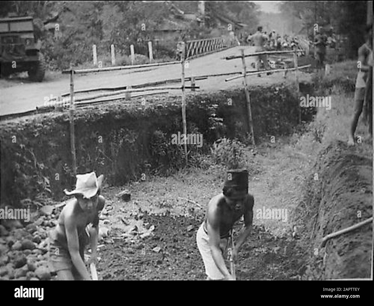 Liberation Kepandjen Nel upmarsweg a Kepandjen (vicino Malang) a Wlingi: Una trappola di carri armati scavata dalle forze repubblicane, è completamente presa dalla popolazione volontariamente e senza la supervisione di poema militare olandese. Sul retro, un ponte parzialmente distrutto. Data: 20 dicembre 1948 luogo: Indonesia, Indonesia, Kepandjen, Malang, Dutch East Indies Parole Chiave: Ponti, carreggiate, trappole per carri armati, distruzione Foto Stock