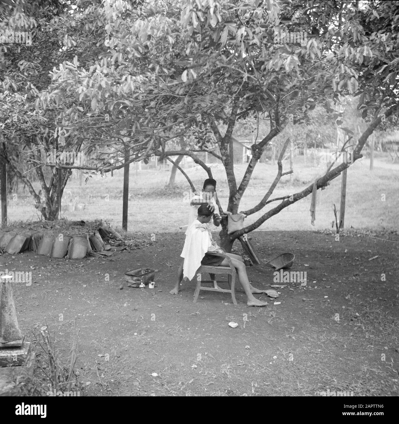 Volontari di guerra a Malacca e Indonesia In un kampong OPJava i capelli di un ragazzo è tagliato all'aperto Data: 1946 luogo: Indonesia, Java, Dutch East Indies Parole Chiave: Parrucchieri Foto Stock