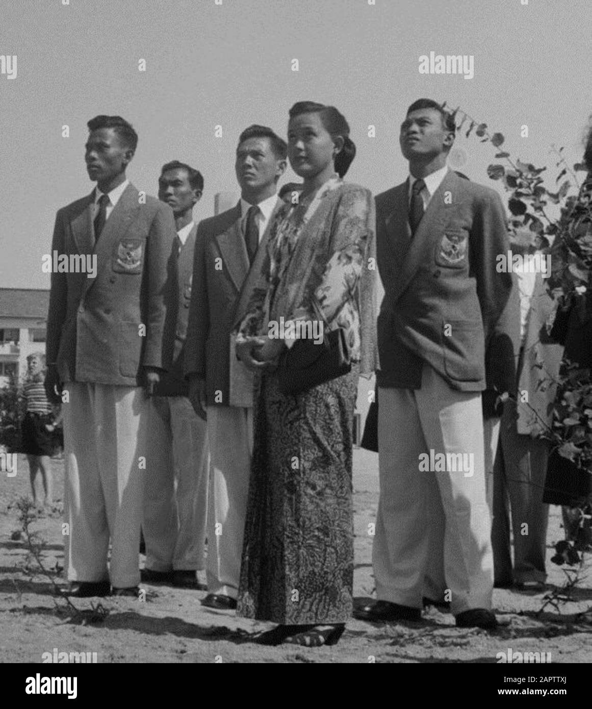 La squadra olimpica indonesiana alle Olimpiadi estive di Helsinki del 1952. La squadra è composta dai tre maschi in mezzo al terreno: Maram Sudarmodjo (salto in alto). Habib Suharko (200 m di nuoto crawl swim), Thio Ging Hwie (sollevamento pesi). La femmina in primo piano non fa parte della squadra e non ha alcun nome nella fonte.; Foto Stock