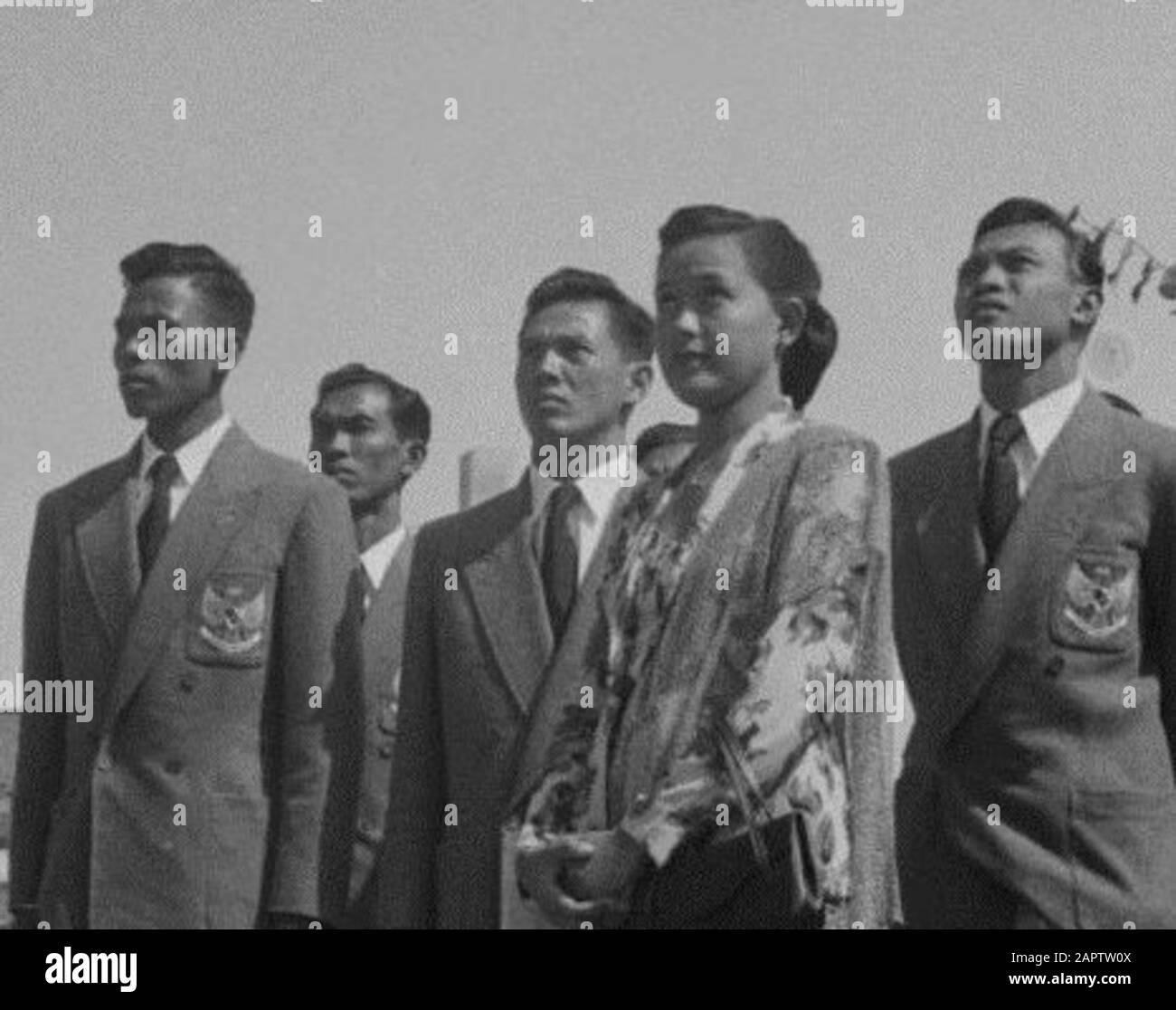 La squadra olimpica indonesiana alle Olimpiadi estive di Helsinki del 1952. La squadra è composta dai tre maschi in mezzo al terreno: Maram Sudarmodjo (salto in alto). Habib Suharko (200 m di nuoto crawl swim), Thio Ging Hwie (sollevamento pesi). La femmina in primo piano è un atleta concorrente e senza nome nella fonte.; Foto Stock