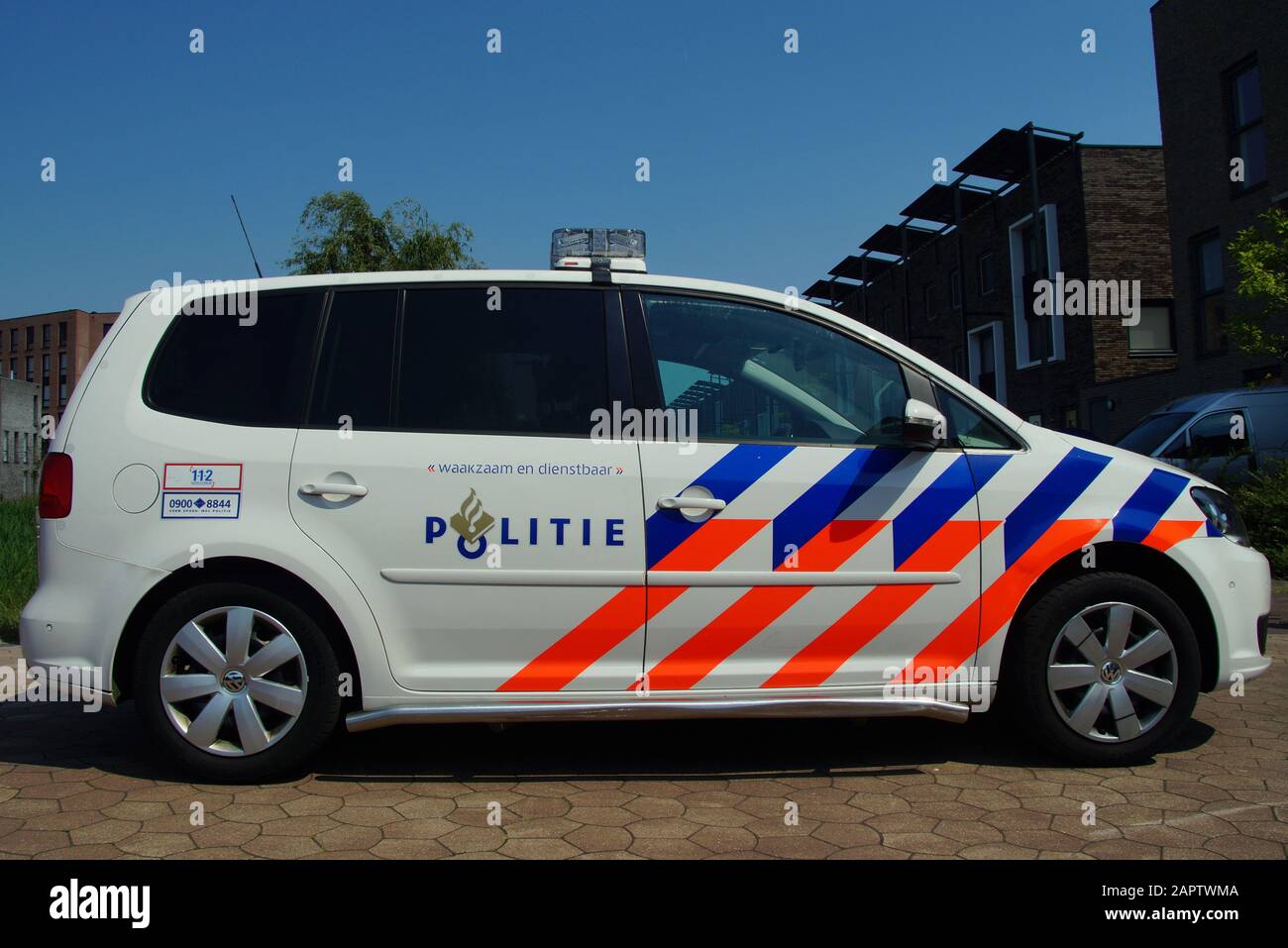 Almere, Paesi Bassi - 5 giugno 2015: Vettura di polizia nazionale olandese (politie), Volkswagen Touran, parcheggiata in una strada urbana di fronte a un palazzo di appartamenti Foto Stock