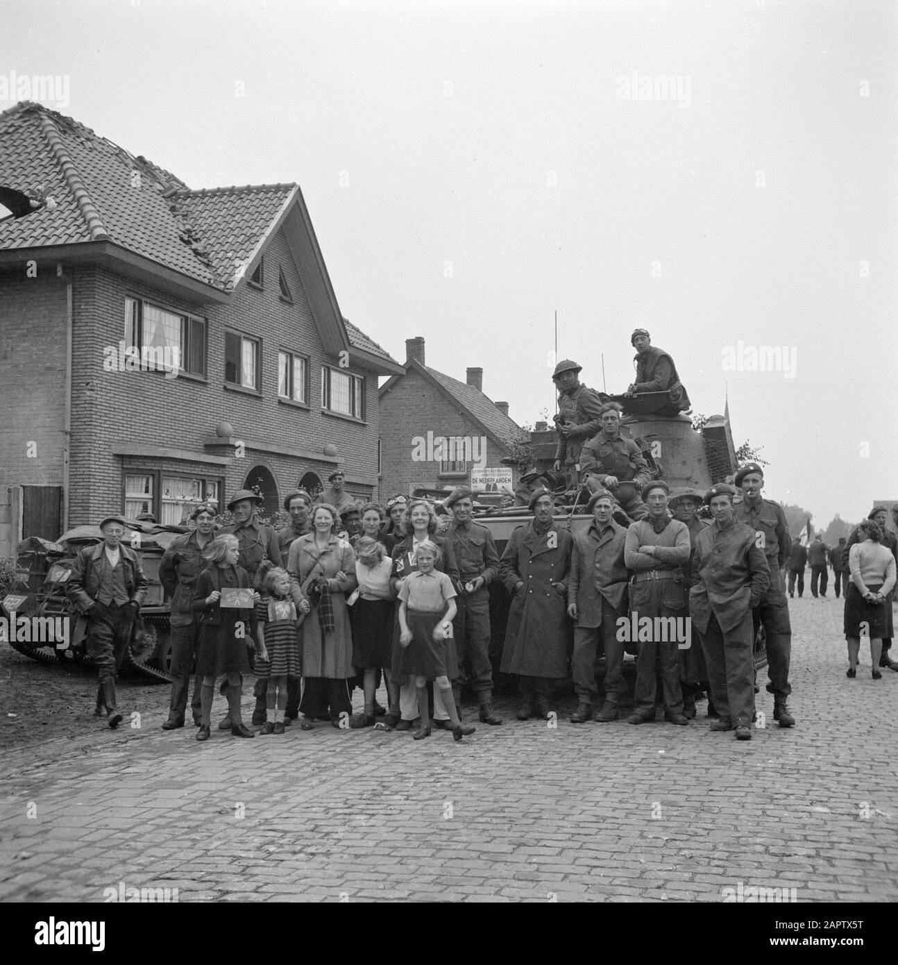 Liberazione del Brabante Nord lungo il corridoio Bergeijk - Valkenswaard - Aalst - Eindhoven Residenti di Aalst posa con soldati della Guardia Irlandese; i bambini hanno bandiere britanniche e americane di carta Data: 18 settembre 1944 luogo: Aalst, Noord-Brabant Parole Chiave: Liberazione, cittadini, villaggi, ritratti di gruppo, militari Foto Stock