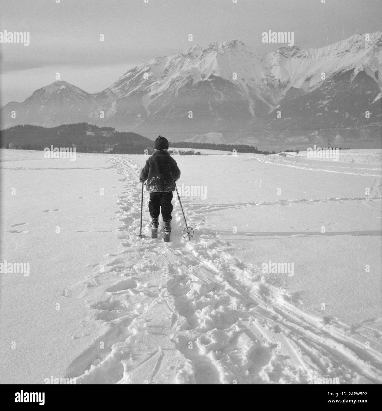 Inverno in Tirolo Bambino con sci nella neve con le montagne del Karwendel in background Data: Gennaio 1960 Località: Austria, Siriani, Tirolo Parole Chiave: Montagne, paesaggi, sci di fondo, sci, neve, inverno, sport invernali Foto Stock