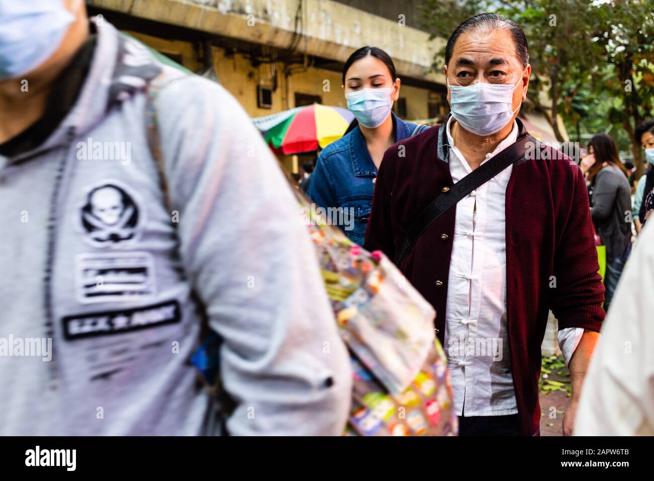 Weary del coronavirus, la gente indossare maschere chirurgiche.Alla luce di un focolaio mortale del virus in Cina, i cittadini di Hong Kong indossavano maschere chirurgiche nel timore di contrarre l'influenza. Con le vacanze Lunar di Capodanno dietro l'angolo, molti cittadini stanno annullando i viaggi in Cina e procedendo con cautela. Foto Stock