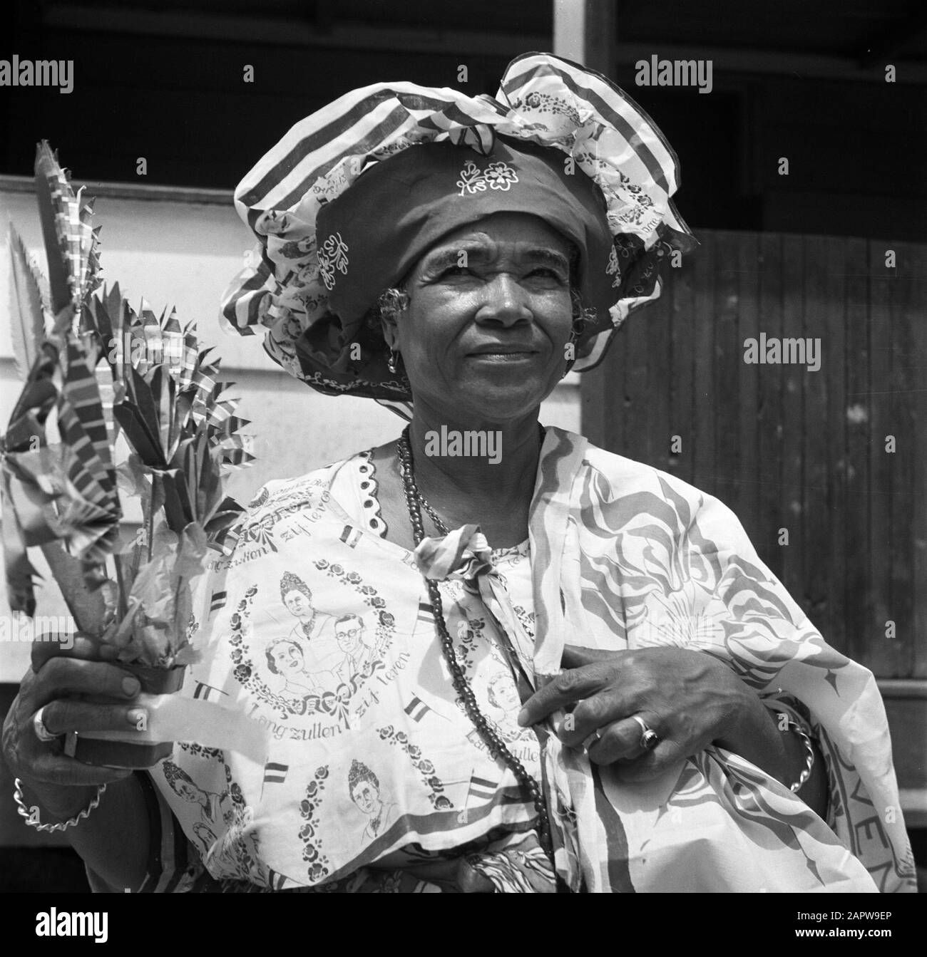Viaggio nel Suriname e nelle Antille Olandesi Kotomisi Pauline vestita con abiti da festa in rosso, bianco, blu e con ritratti della Regina Wilhelmina, della Principessa Juliana e del Principe Bernhard Annotazione: Pauline era la hostess della casa di governo in New Nickerie Data: 1947 Località: Nickerie, Suriname Parole Chiave: creoles, indigeni, abbigliamento, donne Foto Stock