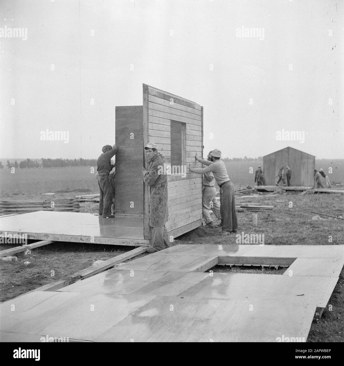 Israele 1948-1949: Costruzione di un nuovo kibbutz membri del team di costruzione di madre kibbutz Yavne assemblare caserme da parti prefabbricate Data: 1948 luogo: Israele, Yavne Parole Chiave: Barakkens, attività di costruzione, materiali da costruzione, operai edili, kibbutz Foto Stock