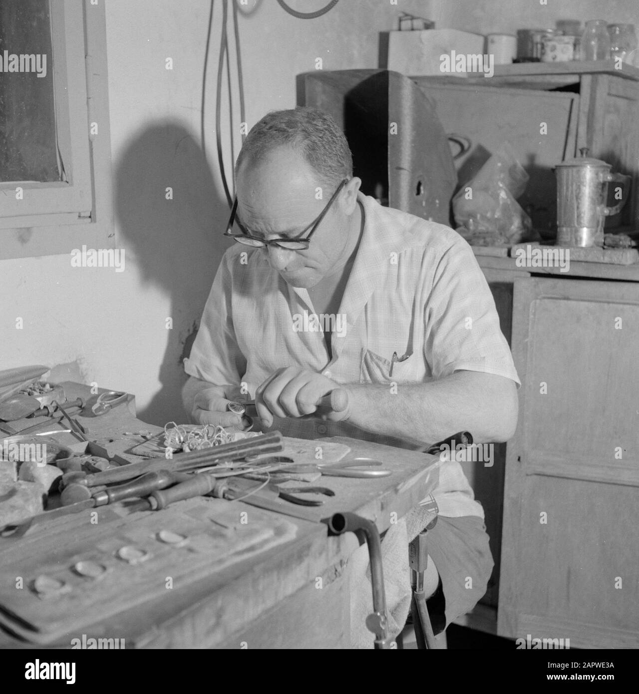 Israele - Eilat Man lavorando sulla pietra di Eilat in anelli in un'azienda in cui questa pietra è lavorata e lavorata. USA un certo strumento Data: 1 gennaio 1963 Località: Eilat, Israele Parole Chiave: Operai, gemme, utensili, pietre semipreziose, industria, macchine, anelli Foto Stock