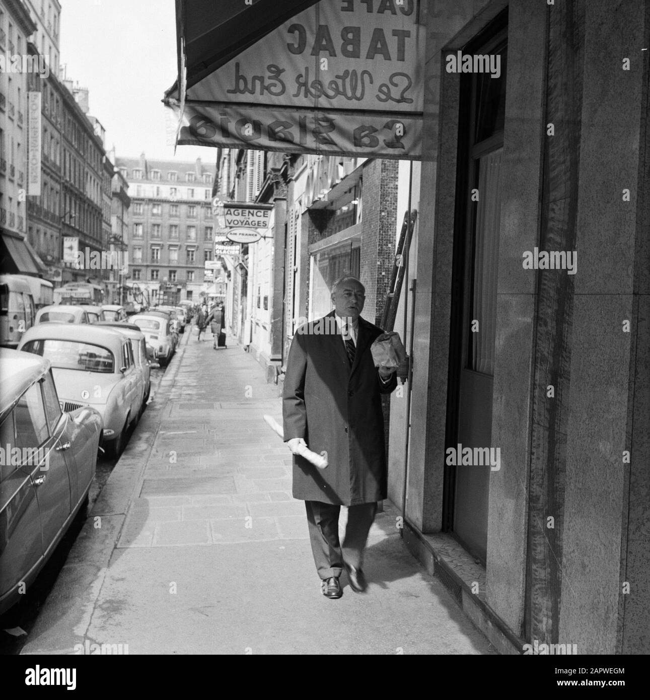 Pariser Bilder [la vita di strada di Parigi] uomo con generi alimentari in una strada commerciale Data: 1965 luogo: Francia, Parigi Parole Chiave: Generi alimentari, pane, sculture di strada, negozi Foto Stock