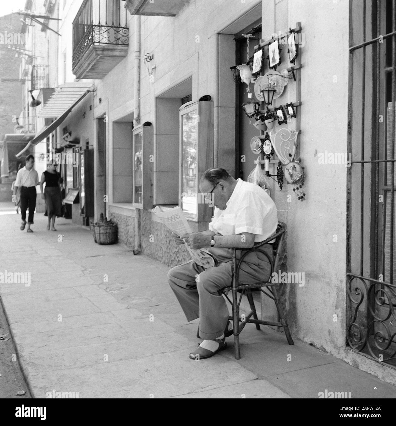 Immagini di strada spagnola l'uomo si siede davanti ad un deposito e legge il giornale Data: Unundated luogo: Spagna Parole Chiave: Leggi, persone, immagini di strada Foto Stock