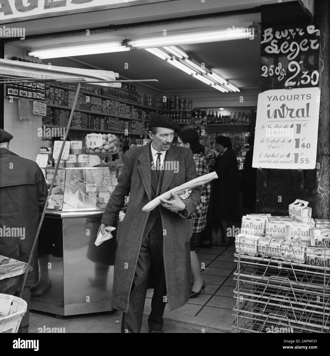 Pariser Bilder [la vita di strada di Parigi] Man Leaves negozio con generi alimentari Data: 1965 luogo: Francia, Parigi Parole Chiave: Generi alimentari, pane, sculture di strada, negozi Foto Stock