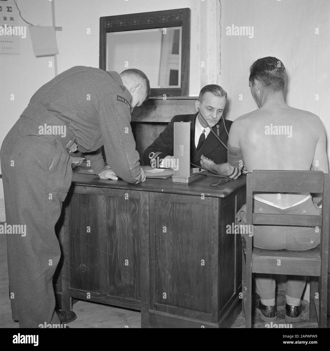 Reportage marino marino. Ispezione. Il Marinologo misura la pressione sanguigna. Dati delle note Mediche Data: 1939 Parole Chiave: Medici, ispezioni, marine Foto Stock