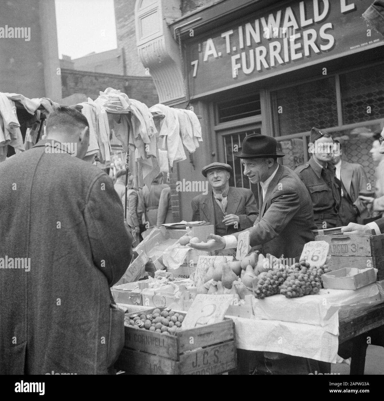 Mercato in Petticoat Lane, London Market Merchant with Fruit si occuperà del cliente Data: 1947 Località: Inghilterra, Londra Parole Chiave: Frutta, mercati Foto Stock