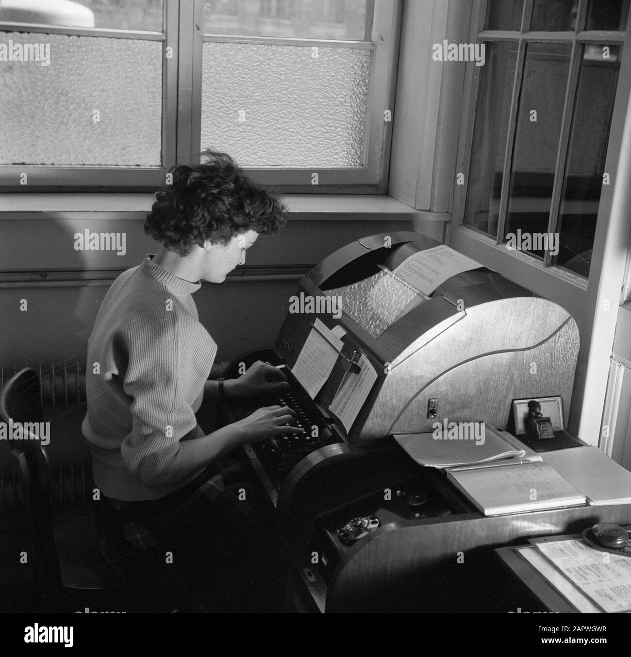 Navigazione sul Reno, rapporto di Tug Damco 9: Germania occidentale Employewoman in ufficio Duisburg-Ruhrort dietro una macchina telex Data: 1 aprile 1955 Località: Duisburg, Germania, Germania occidentale Parole Chiave : personale amministrativo, uffici, telecomunicazioni Foto Stock Navigazione sul Reno, rapporto di Tug Damco 9: Germania occidentale Employewoman in ufficio Duisburg-Ruhrort dietro una macchina telex Data: 1 aprile 1955 Località: Duisburg, Germania, Germania occidentale Parole Chiave : personale amministrativo, uffici, telecomunicazioni Foto Stock