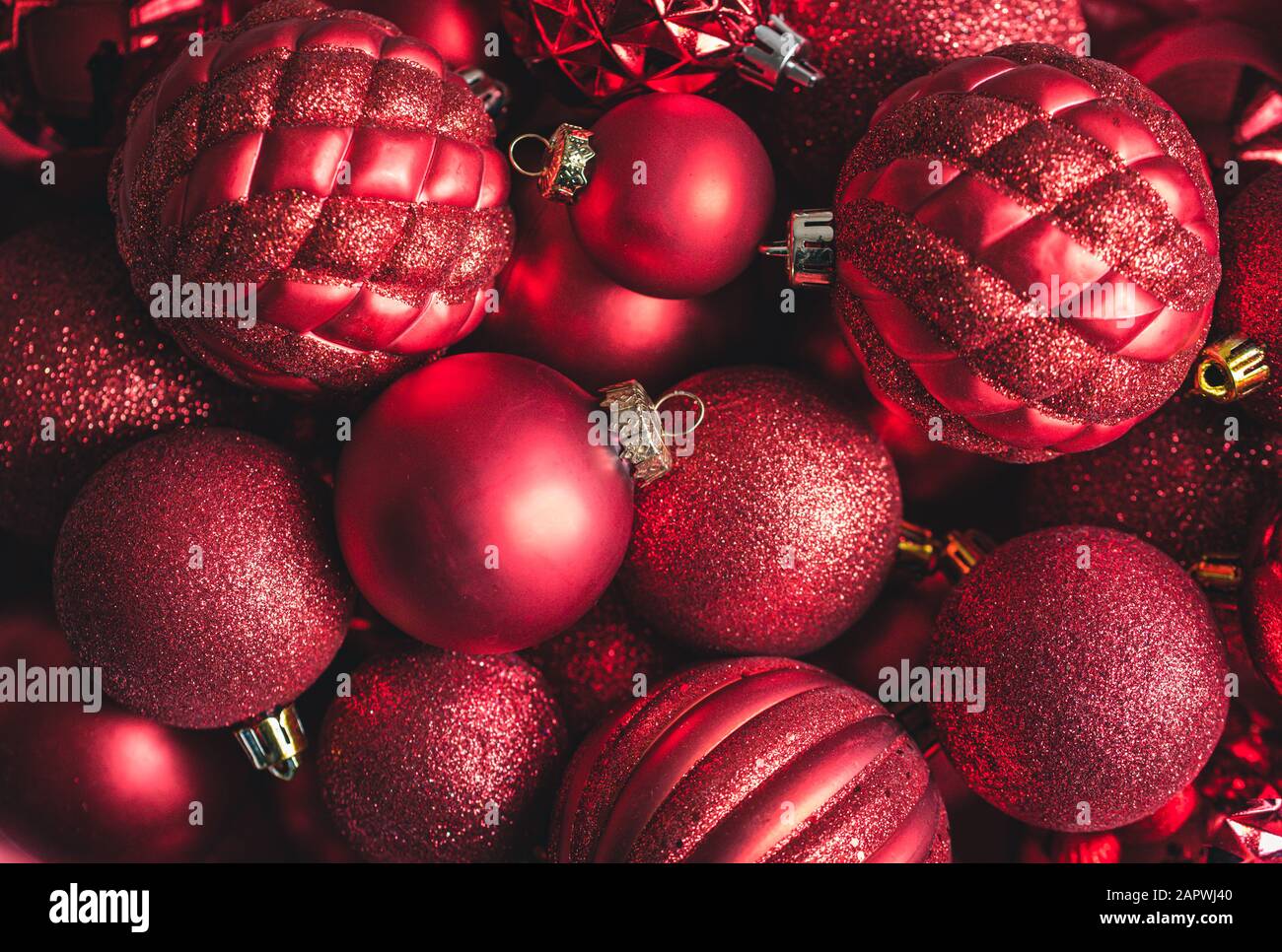 Primo piano ad angolo alto con una varietà di ornamenti di palle natalizie rosse. Foto Stock