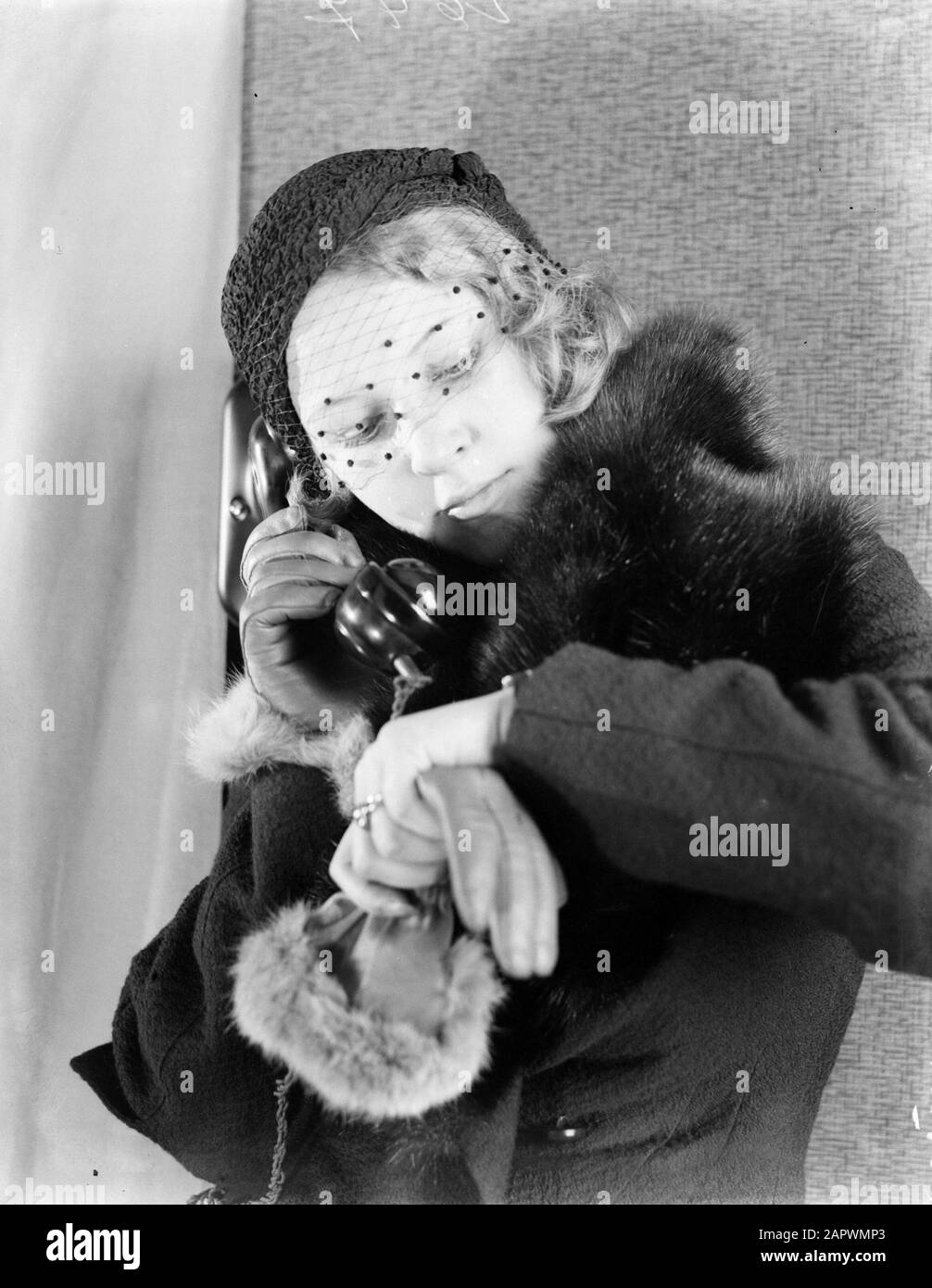 Modello di Reportage Eva Waldschmidt al telefono; guarda all'orologio Data: 1933 Parole Chiave: Pelliccia, modelli fotografici, orologi, telefoni Nome personale: Waldschmidt, Eva Foto Stock
