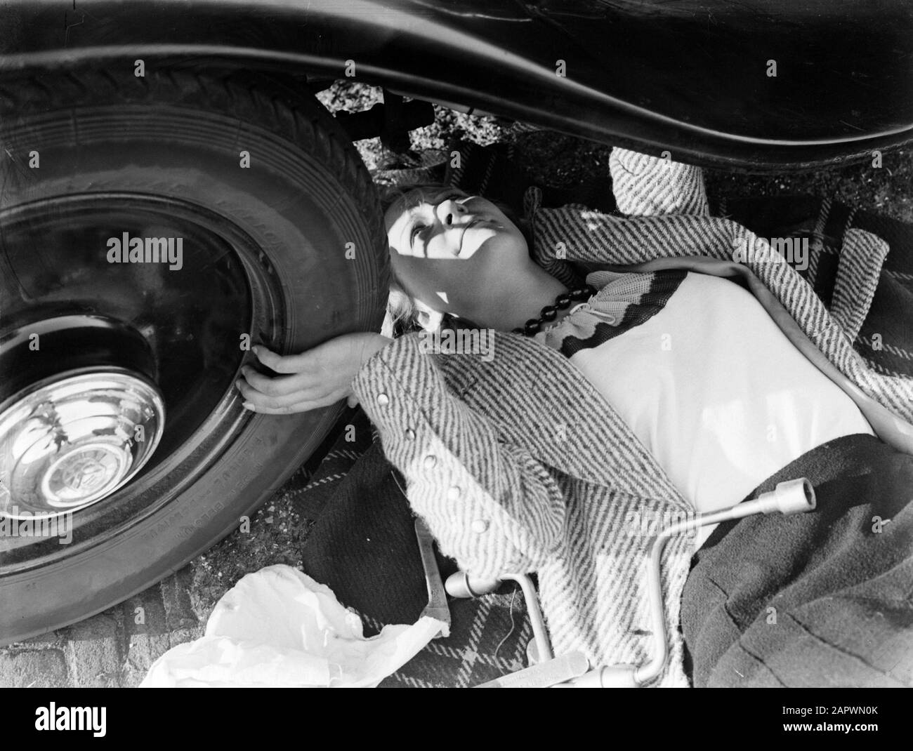 Modello di Reportage Eva Waldschmidt guarda sotto la vettura Data: 1933 Parole Chiave: Automobili, donne Nome Persona: Waldschmidt, Eva Foto Stock