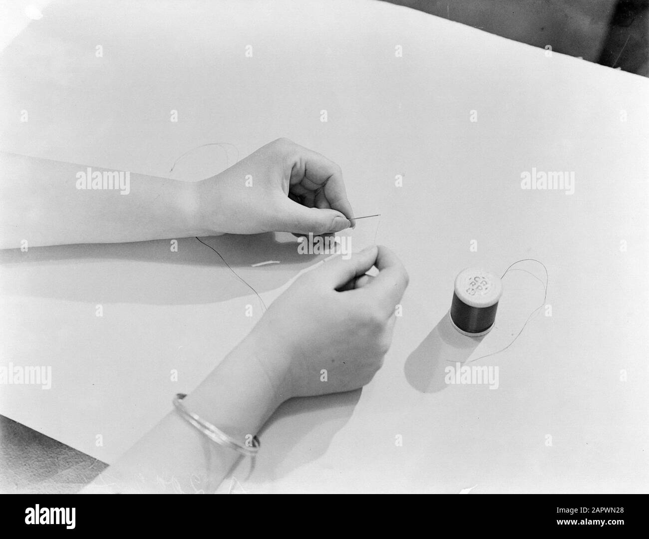 Modello di Reportage Eva Waldschmidt inserisce un filo in un ago Data: Parole Chiave non date: Modelli fotografici, sarti Nome personale: Waldschmidt, Eva Foto Stock