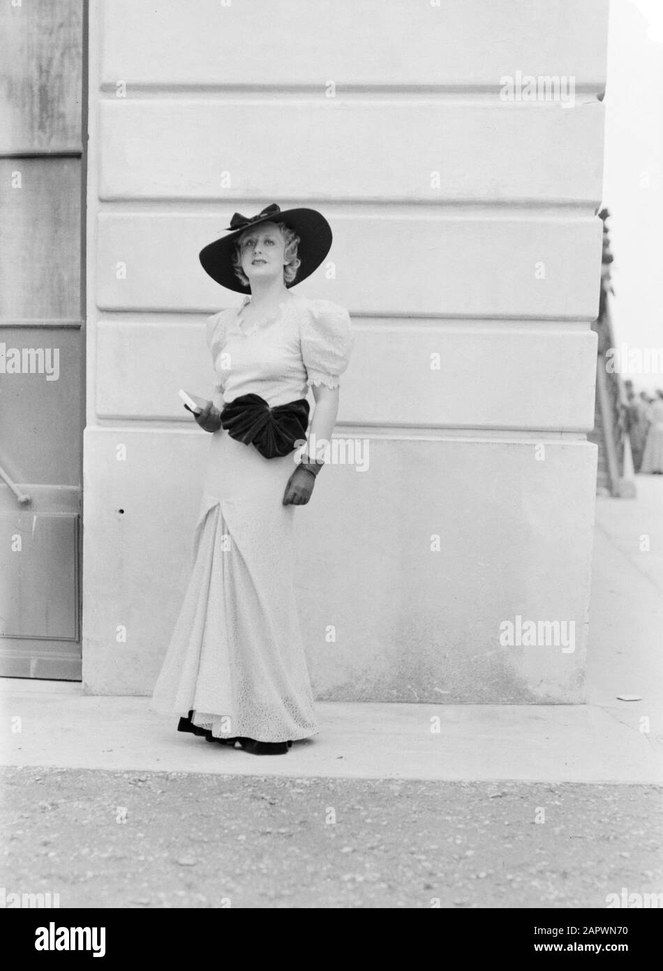 Foto di moda in Auteuil modello in abito lungo con cappello Data: 28 Giugno 1936 luogo: Francia, Parigi Parole Chiave: Abbigliamento, moda Foto Stock