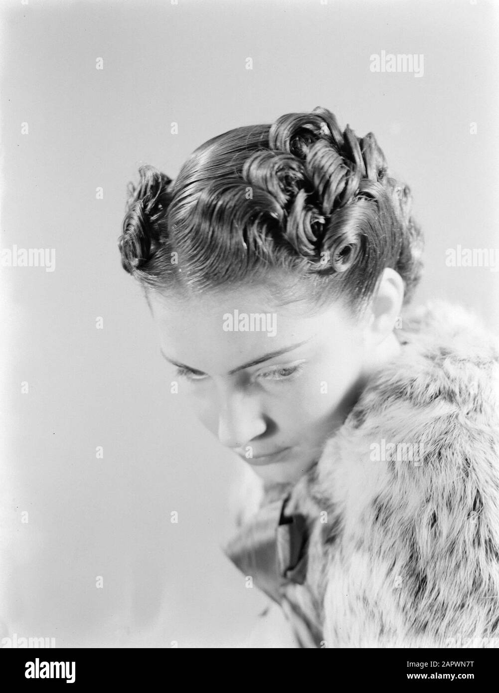 Advertising photography Model with an ingegnous hairstyle Annotation: On map system Van de Poll ha scritto: 'Hairstyles of Antwerpen' Data: Febbraio 1940 Parole Chiave: Modelli fotografici, acconciature Foto Stock