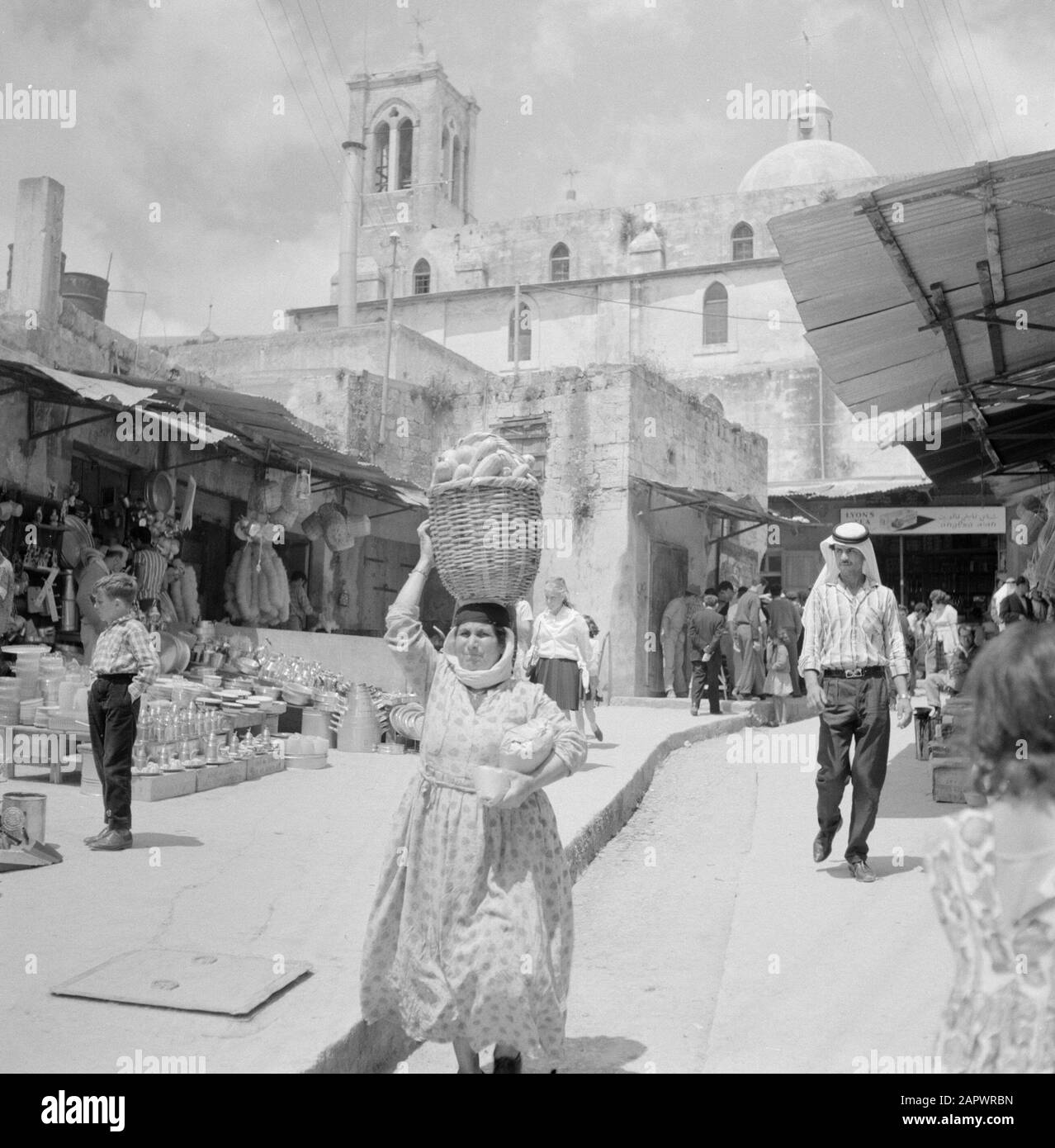 Israele: Nazaret Nazareth. Via dello shopping con in primo piano una donna con un cesto sulla sua testa e con sullo sfondo la chiesa dell'Annunciazione Data: Undata: Galilea, Israele, Nazareth Parole Chiave: Articoli per la casa, edifici della chiesa, neo-gotico, statue di strada, donne, shopping Foto Stock