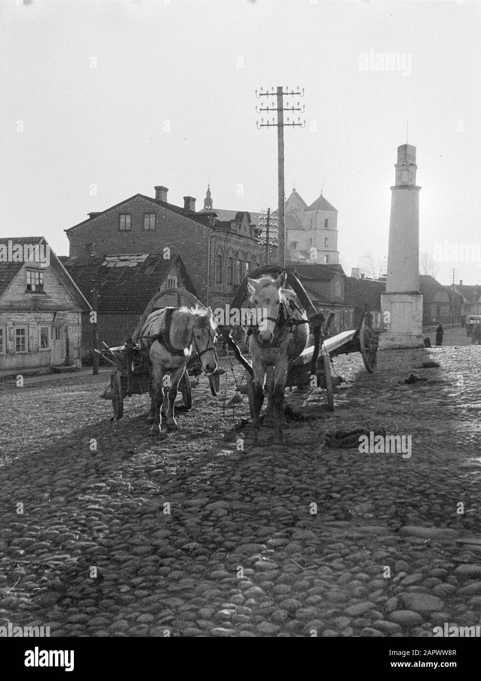 Viaggio In Lituania Novy Troky (Trakai). Piazza con due cavalli, ciascuno per un carro steso nelle case di fondo e la chiesa parrocchiale di Santa Maria. Sulla destra una colonna su un piedistallo di mattoni di cui è stata rimossa la statua coronante dei santi e su cui è posta una barra fulminea. Annotazione: Sulla colonna di vecchio si trovava una statua di San Giovanni di Nepomuk. Durante la dominazione russa, questa immagine è stata rimossa. Sotto il governo polacco, l'aquila polacca ha vinto la colonna per un certo tempo. Dopo il ristabilimento dello stato lituano, San Giovanni di Nepomuk ancora una volta adorna la colonna Foto Stock