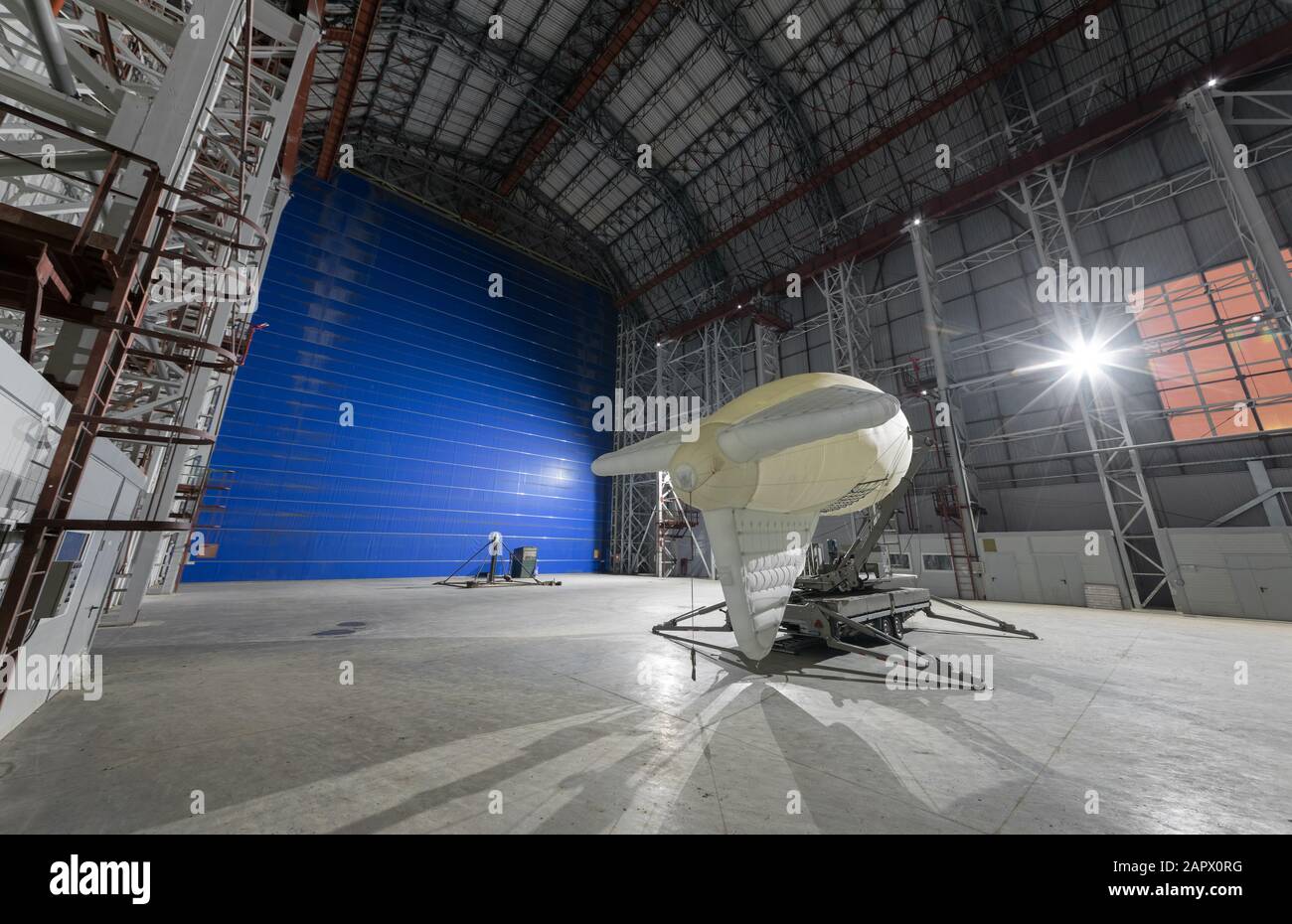 Aerostat su una piattaforma di ormeggio mobile all'interno di un gigantesco hangar airship enormi cancelli blu Foto Stock