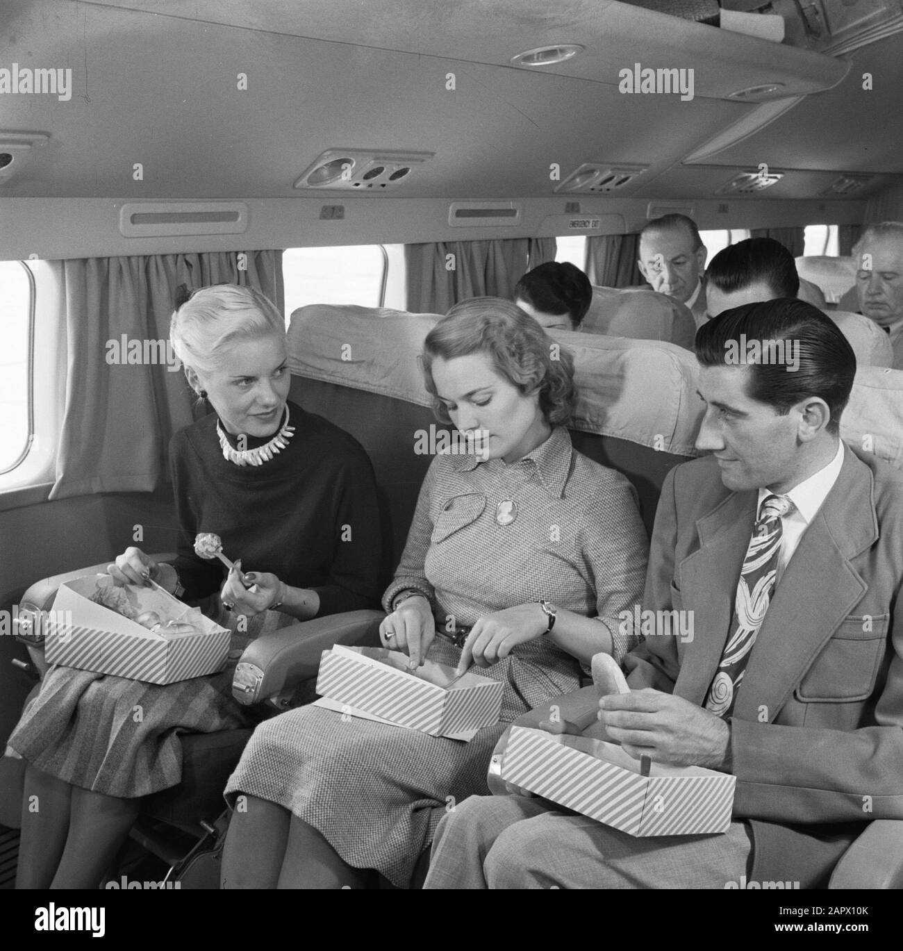 Pubblicità i Passeggeri KLM mangiano un panino a bordo di un aereo passeggeri KLM Data: 1950 Parole Chiave: Interni, pasti, viaggiatori, aeroplani Nome istituto: KLM, Schiphol Foto Stock Pubblicità i Passeggeri KLM mangiano un panino a bordo di un aereo passeggeri KLM Data: 1950 Parole Chiave: Interni, pasti, viaggiatori, aeroplani Nome istituto: KLM, Schiphol Foto Stock