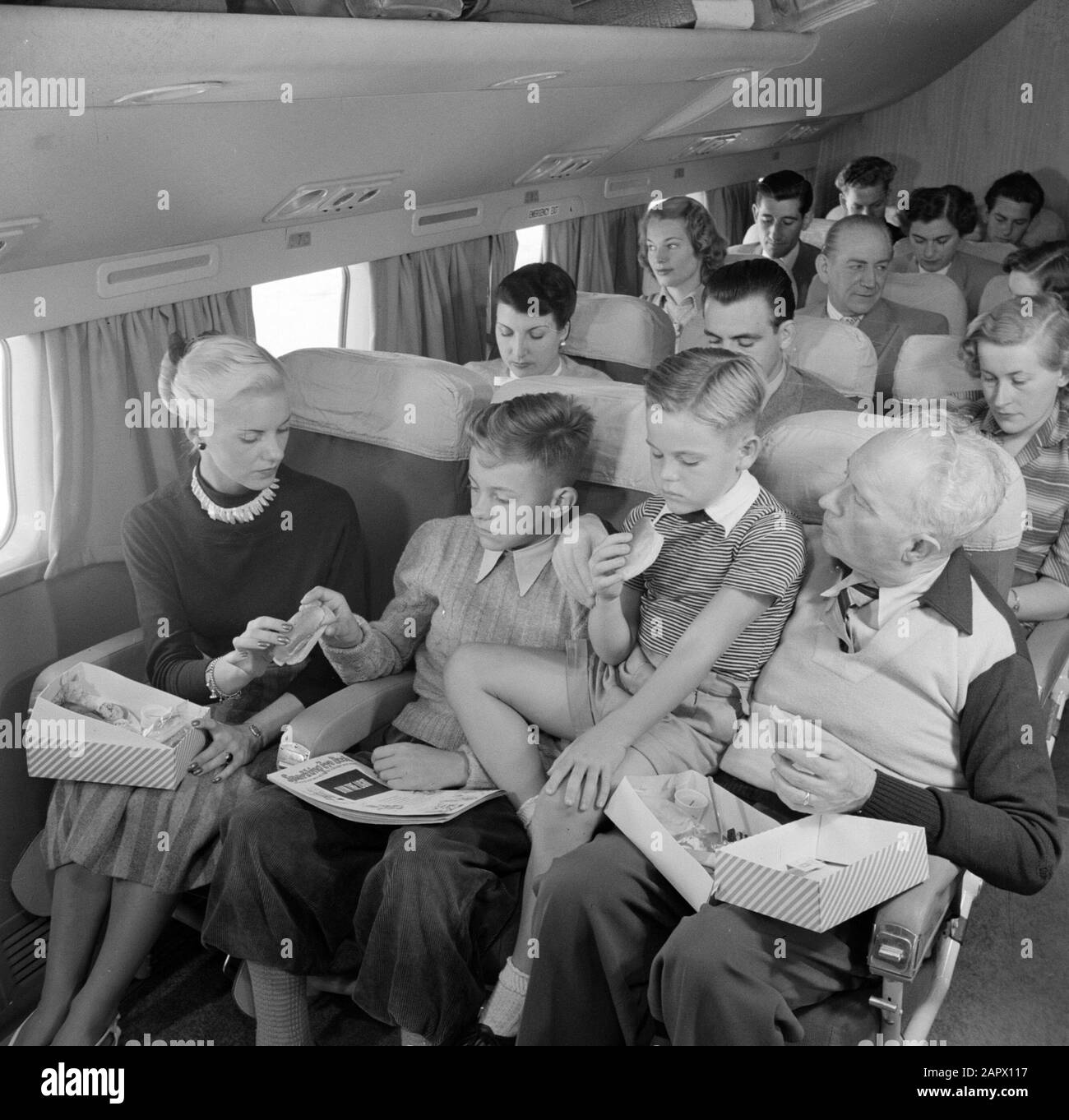 Pubblicità i Passeggeri KLM mangiano un panino a bordo di un aereo passeggeri KLM Data: 1950 Parole Chiave: Interni, pasti, viaggiatori, aeroplani Nome istituto: KLM, Schiphol Foto Stock Pubblicità i Passeggeri KLM mangiano un panino a bordo di un aereo passeggeri KLM Data: 1950 Parole Chiave: Interni, pasti, viaggiatori, aeroplani Nome istituto: KLM, Schiphol Foto Stock