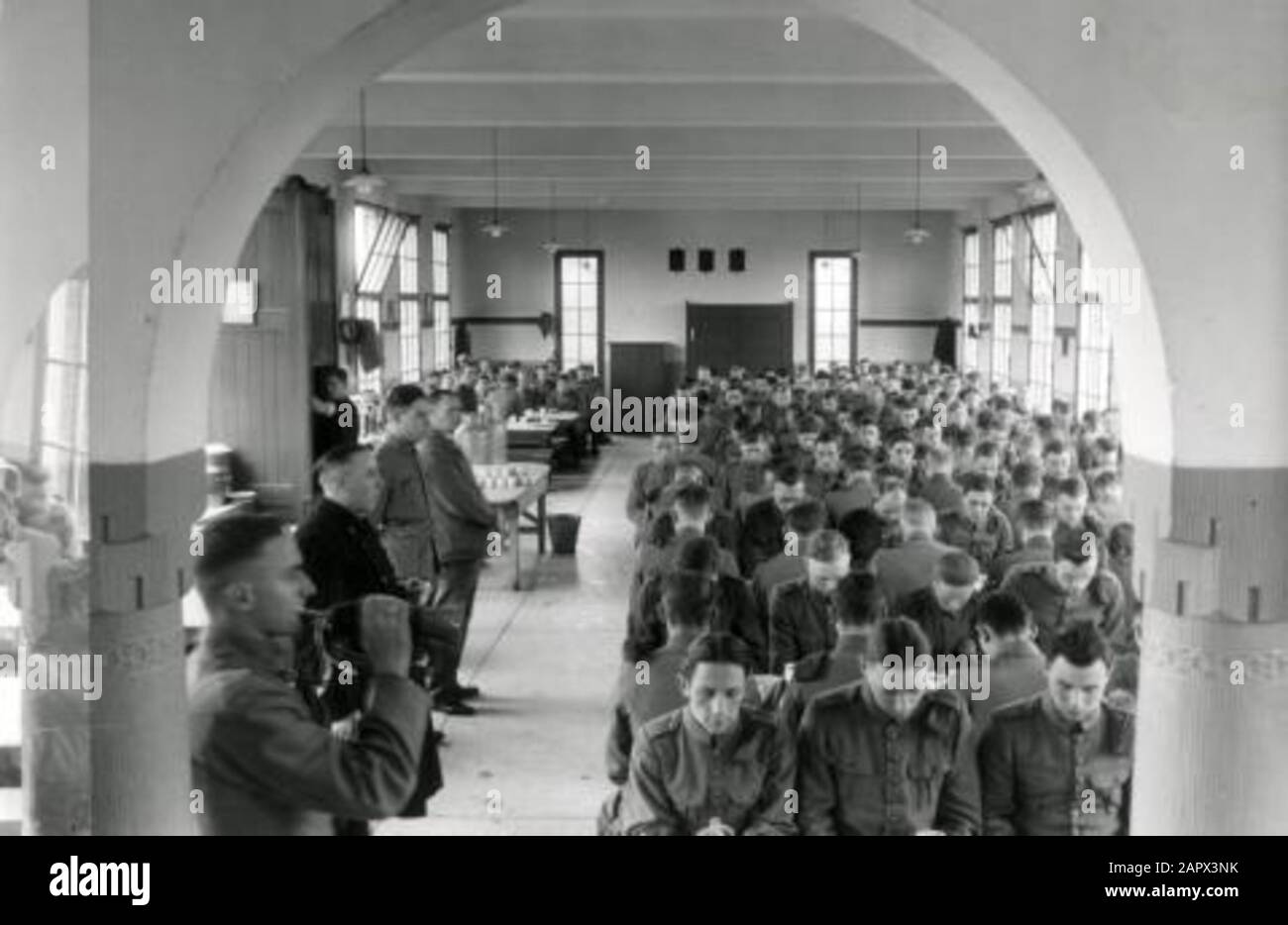 Esercito olandese, truppe coloniali, KNIL. Sala da pranzo della caserma della Riserva coloniale di Nijmegen. Uomini in preghiera al tavolo, a sinistra il corno soffiatore. Paesi Bassi, 1939. Foto Stock