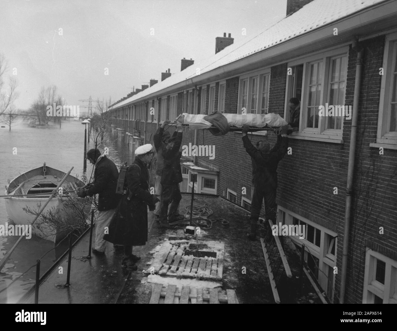 Rampa Tuindorp Oostzaan, uno dei malati con barella da casa Data: 14 gennaio 1960 luogo: Oostzaan Parole Chiave: Case, Disastri, Malati, barelle Foto Stock