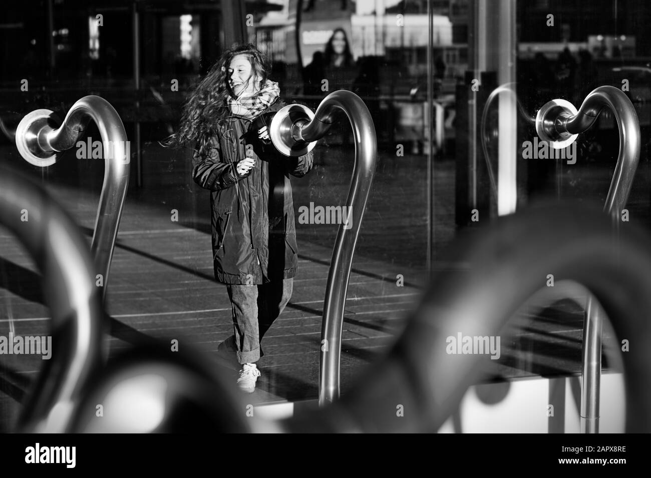 Ragazza con i capelli nel vento sorridente in 'le voci della città' artkork (Garutti, 2012) composto da tubi intercom in piazza Gae Aulenti, Milano, Italia Foto Stock