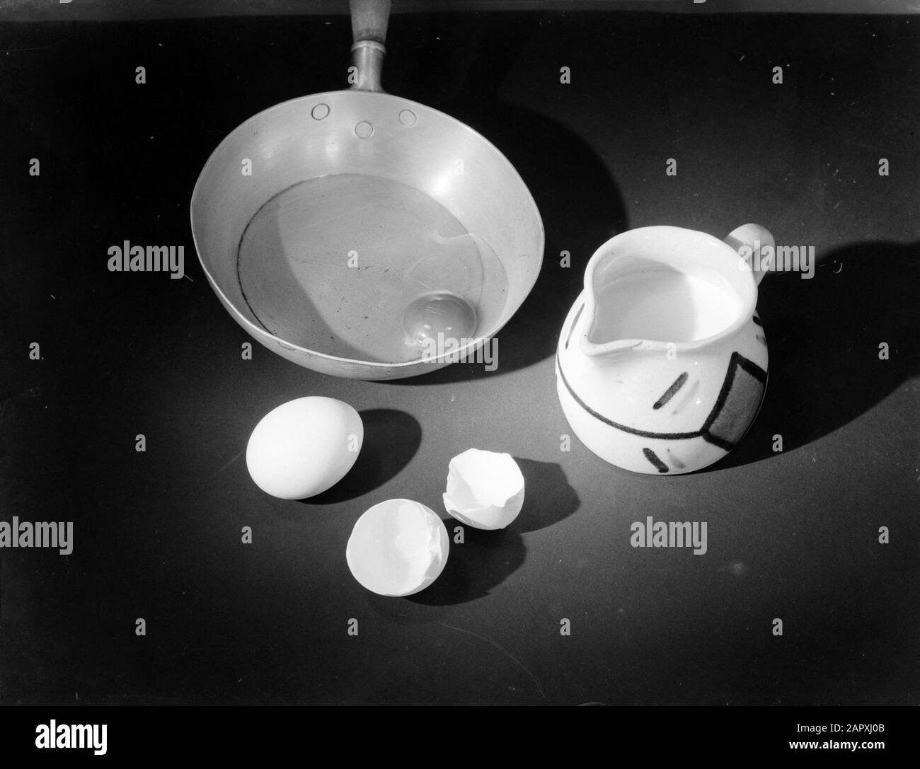 Pubblicità fotografia Ancora vita di una padella, una brocca crema e uova Data: 1932 Parole Chiave: Uova, padelle, brocche crema, ancora vita Foto Stock