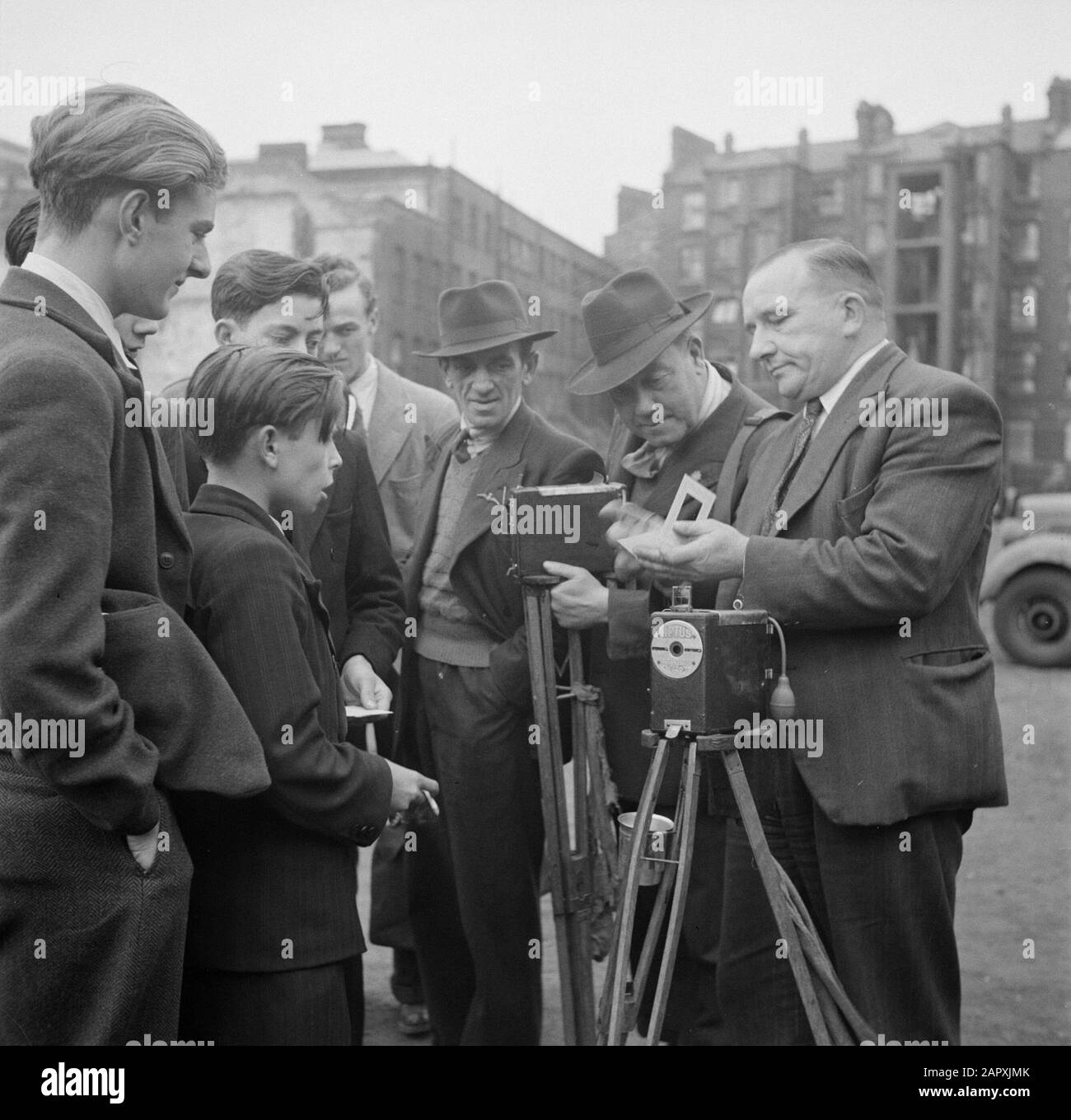 Mercato in Petticoat Lane, London Street fotografo ferma una foto di alcuni ragazzi appena preso con la sua fotocamera Aptus (a sinistra) in un caso Data: 1947 posizione: Inghilterra, Londra Parole Chiave: Fotocamere, fotografi, ragazzi, immagini di strada Foto Stock