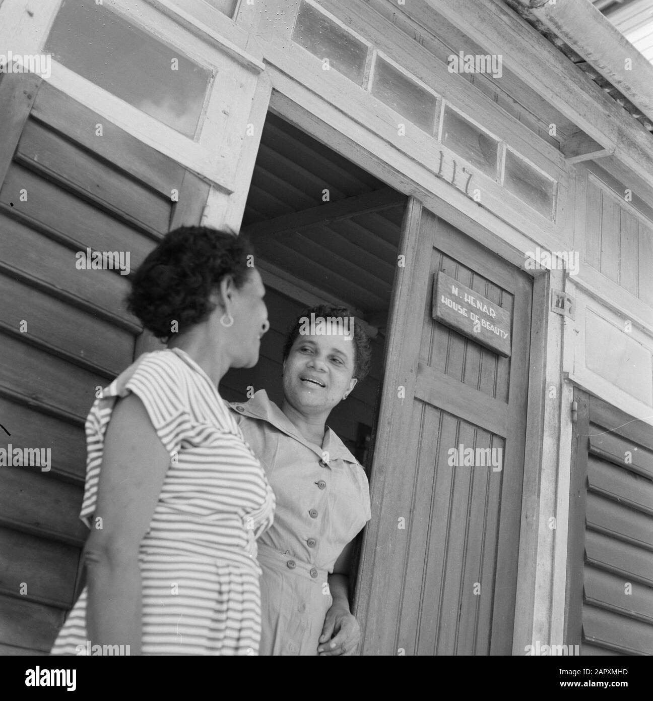 Antille Olandesi e Suriname al momento della visita reale della Regina Juliana e del Principe Bernhard nel 1955 Tilly e Miltje di fronte alla casa (no 117) di madre Henar in Paramaribo Data: 1 ottobre 1955 Ubicazione: Paramaribo, Suriname Parole Chiave: Edifici, donne Nome personale: Henar Foto Stock
