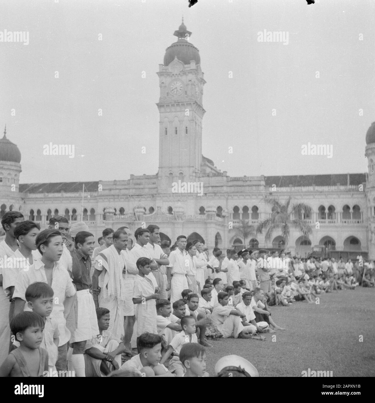 Volontari di guerra a Malacca e Indonesia Spettatori in una partita di calcio di fronte al Parlamento edificio a Kuala Lumpur Annotazione: Pubblicato in 'Guys of Deed' Data: 1946 luogo: Kuala Lumpur, Malacca, Malesia Parole Chiave: Edifici, pubblico, calcio Foto Stock
