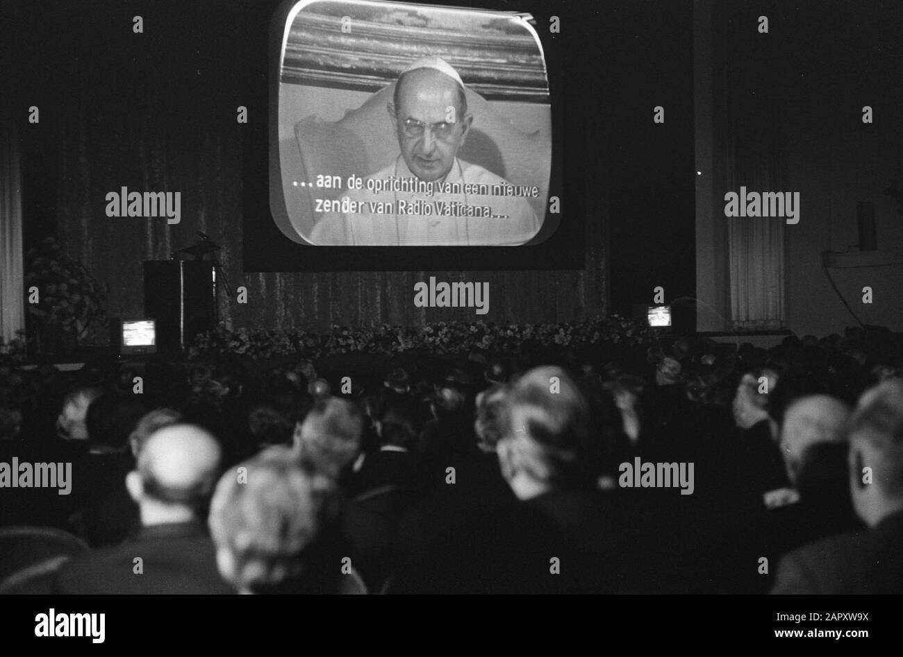 Celebrazione del quarantesimo anniversario della radio cattolica (K.R.O.) nel teatro Gooiland a Hilversum Via televisione a grande schermo l'incontro è affrontato da Papa Paolo VI Data: 15 novembre 1965 luogo: Hilversum, Utrecht Parole Chiave: Jubilees, media, ministri, radio, televisione, discorsi, incontri Nome personale: Paolo VI Nome istituzionale: Kro Foto Stock