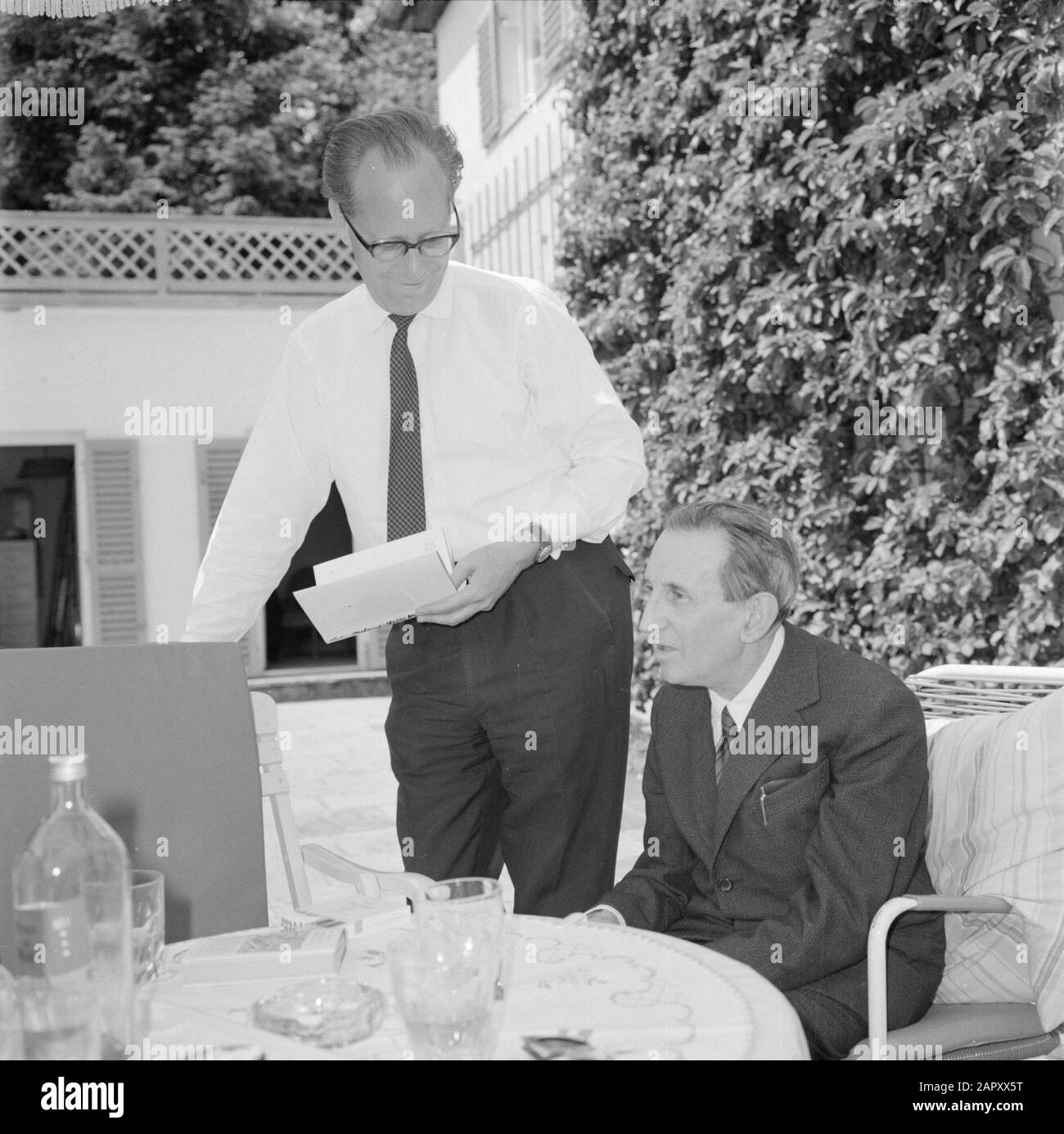 Visita A Ibking V.l.n.r. Hermann Kreisselmeier e Walter Mehring seduti su una terrazza Data: Giugno 1964 luogo: Germania, Monaco di Baviera, Germania occidentale Parole Chiave: Libri, bevande, mobili, fumo, scrittori, stoviglie, terrazze, giardini, case Nome personale: Kreisselmeier, Hermann, Mehring, Walter Foto Stock