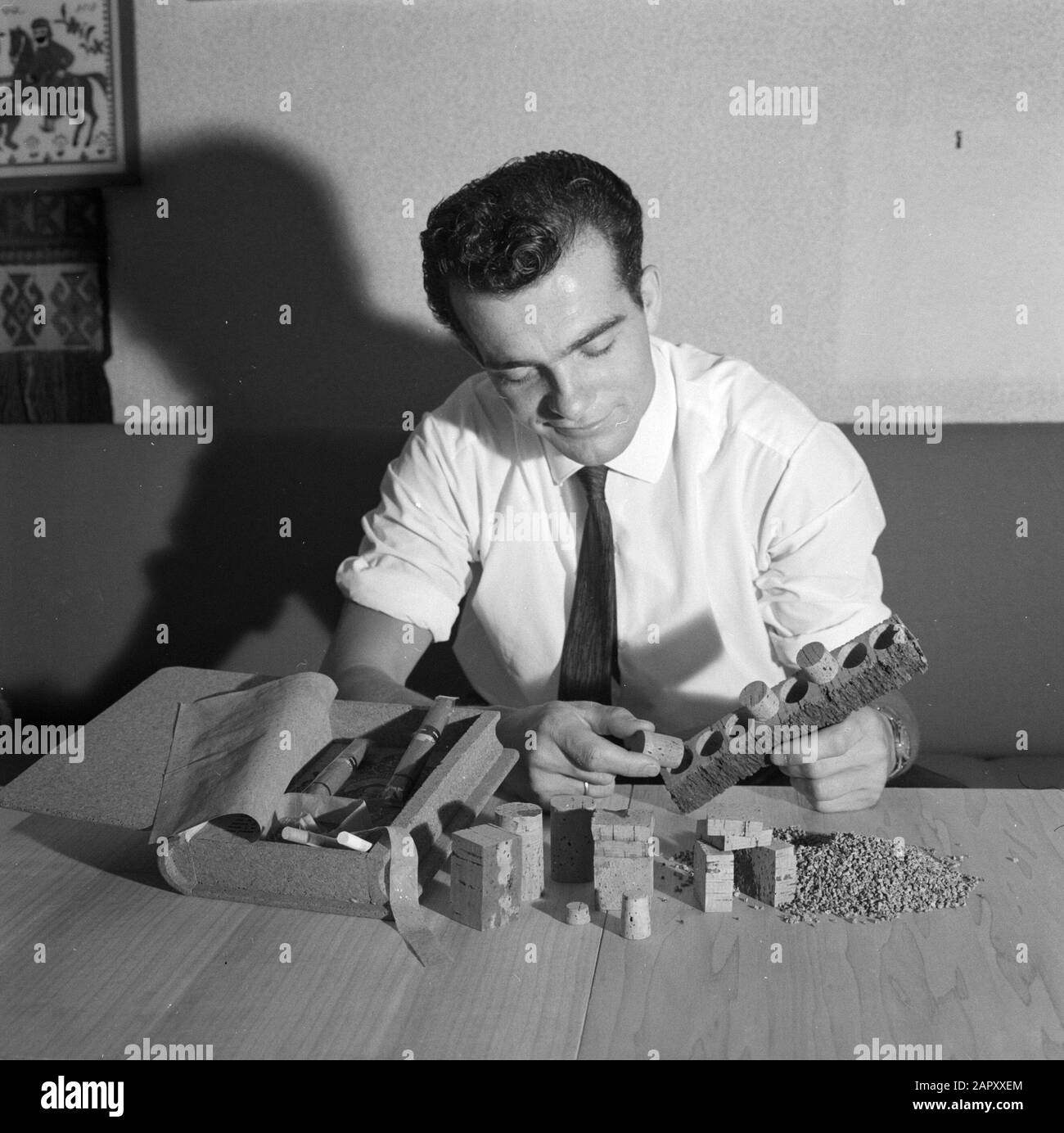 L'uomo adulto gioca con sughero. Accanto a lui sigari in una scatola di sigari camoufled come libro Data: Parole Chiave dense: Artigianato, sughero, gioco Foto Stock