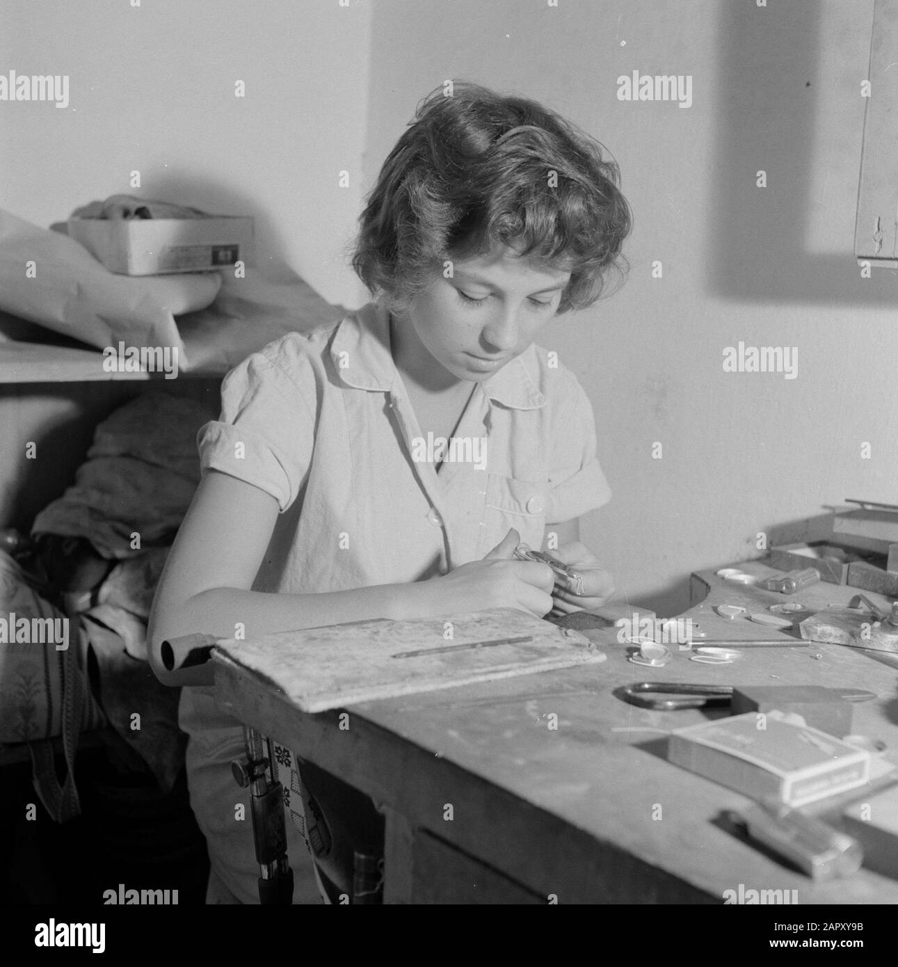 Israele - Eilat Woman lavorando su pietra Eilat in gioielleria in un'azienda in cui questa pietra è lavorata e lavorata. Data: 1 gennaio 1963 luogo: Eilat, Israele Parole Chiave: Operai, gemme, attrezzi, pietre semipreziose, industria, macchine, anelli Foto Stock