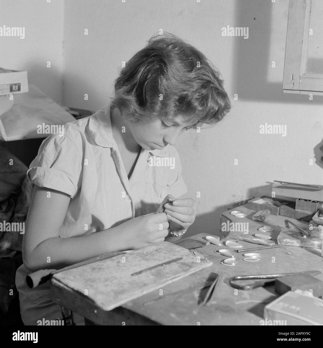 Israele - Eilat Woman lavorando su pietra Eilat in gioielleria in un'azienda in cui questa pietra è lavorata e lavorata. Data: 1 gennaio 1963 luogo: Eilat, Israele Parole Chiave: Operai, gemme, attrezzi, pietre semipreziose, industria, macchine, anelli Foto Stock