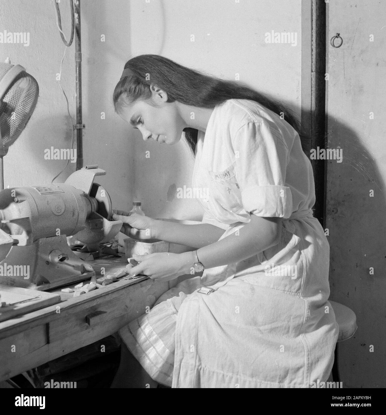 Israele - Eilat Woman lavorando alla macinazione della pietra Eilat in un'azienda in cui questa pietra viene lavorata e lavorata. Data: 1 gennaio 1963 luogo: Eilat, Israele Parole Chiave: Operai, gemme, pietre semipreziose, industria, macchine, smerigliatrici Foto Stock