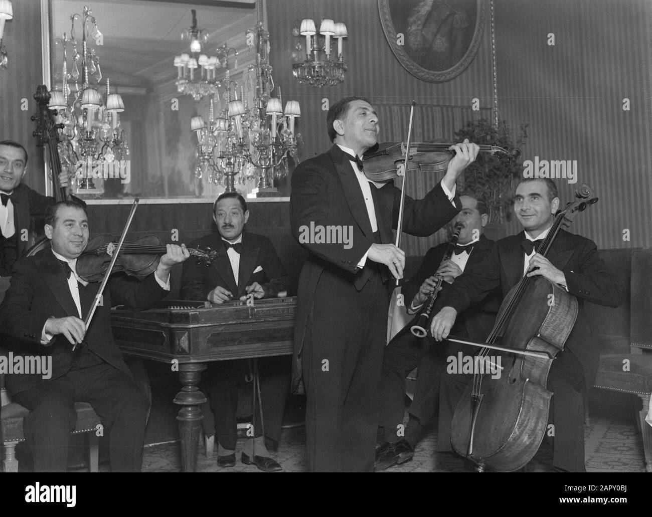 Viaggio In Polonia Varsavia. Gypsy Orchestra suona nella cantina di Fukier Annotazione: I Fukiers erano strettamente collegati con la famiglia bancaria tedesca meridionale Fugger, qualunque nome avessero originariamente. La loro cantina fiorì attraverso i secoli e molte grandi persone della terra la visitarono. Nel 1926, la famiglia vendette l'azienda per un bisogno di soldi. Tuttavia, il nuovo proprietario ha continuato a portare il vecchio nome. L'edificio in cui si trovava la cantina dal 1805 fu perso nel 1944, ma fu ricostruito dopo il 1945 e un ristorante fu fondato sotto il vecchio nome. Date: 1934 Location: Italy, Italy Keywords Foto Stock