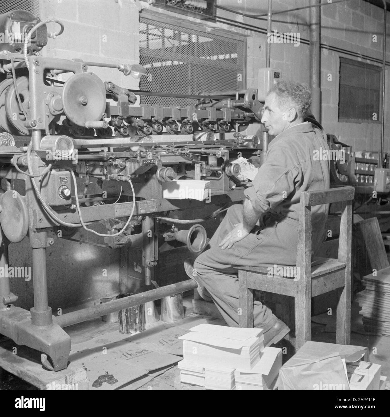Israele 1948-1949 dipendente della fabbrica di succhi di agrumi Assis sulla strada da Tel Aviv a Haifa impegnato nella linea di assemblaggio con il rivestimento di lattine di succo di agrumi con un'etichetta Data: 1948 posizione: Haifa, Israele, Tel Aviv Parole Chiave: Agrumi, imballaggio, fabbriche, trasportatori, macchine, succhi di frutta Foto Stock